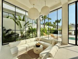 a living room with a white couch and large windows at Dolce x The Young Villas in Uluwatu