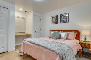 a bedroom with a bed with a pink comforter at Utah Valley Basecamp: Apt for Hikers & Explorers! in Spanish Fork