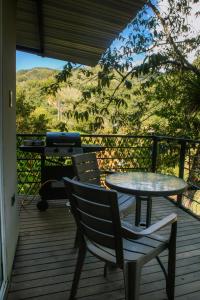 a patio with two tables and a grill on a deck at Natural Glamping Cocorna in Cocorná