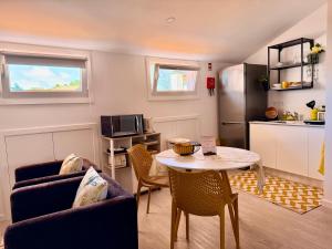 a living room with a table and a kitchen at Ripado Loft in Ponta Delgada