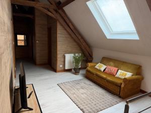 a living room with a couch and a skylight at Gîte Les Jacquets in Hautefort