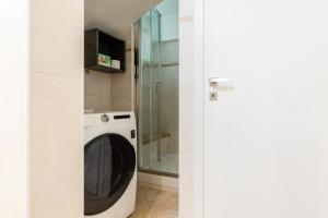a washing machine in a bathroom with a glass shower at Aosta Centre Apartments - Santo Stefano in Aosta