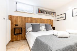 a bedroom with a large bed and a wooden wall at Aosta Centre Apartments - Santo Stefano in Aosta +27 photos