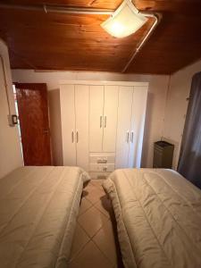 a bedroom with two beds and white cabinets at Servicios Alvarez in Rincon de los Sauces