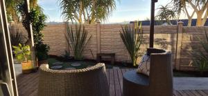 a patio with two wicker chairs and a fence at Camperdown Stay in Camperdown
