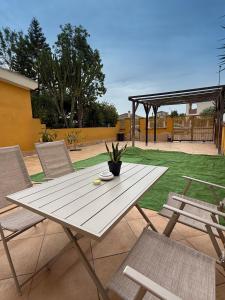 a white picnic table and chairs on a patio at Maya Apartments in La Maddalena