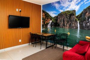 a room with a table and a view of a waterfall at Pousada Lagus Pan in Capitólio