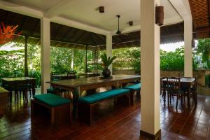 a dining room with a wooden table and chairs at Sri Yoga Shala in Unawatuna +15 photos