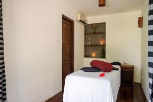 a bedroom with a bed with a red pillow on it at Sri Yoga Shala in Unawatuna