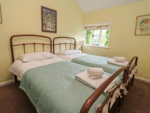 two beds sitting next to each other in a bedroom at Wolvesacre Mill Cottage in Whitchurch