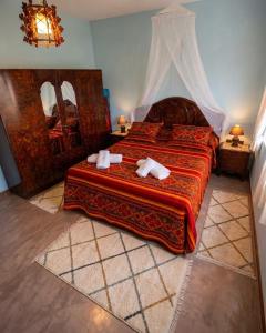 a bedroom with a bed with two towels on it at Desert Stars Oasis in Aoufous