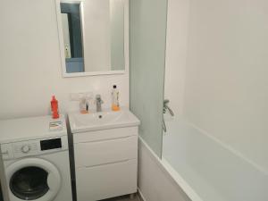 a white bathroom with a washing machine and a sink at Уютная комната в квартире в ЖК Одесский Бульвар in Teremki