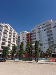 a row of apartment buildings on the beach with trees at Shengjin Paradise Apartment in Shëngjin