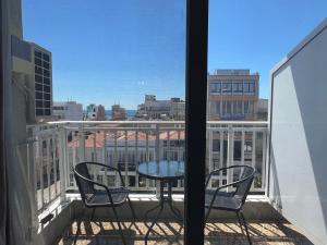 a balcony with a table and chairs and a view of a city at Downtown Hub 1 in Alexandroupoli