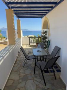 a patio with a table and chairs on a balcony at Natasa studios Kythera in Kythira