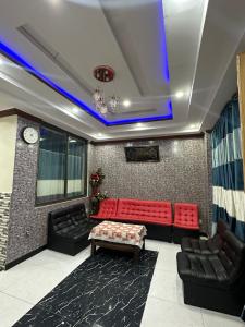 a living room with red and black couches and a clock at Bhurban Family Apartments in Murree