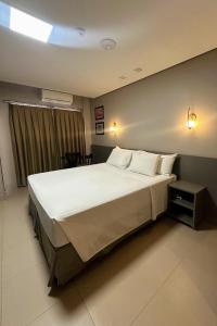 a bedroom with a large bed with white sheets and pillows at Orla Morena Park Hotel in Campo Grande +30 photos