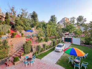 a car parked in a yard with an umbrella at Bhurban Family Apartments in Murree