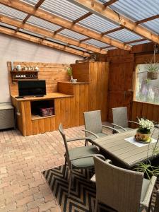 a patio with a table and chairs and a television at Apartmán Gál 1 in Kvačany +2 photos