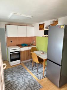a small kitchen with a refrigerator and a table at Apartmán Gál 1 in Kvačany