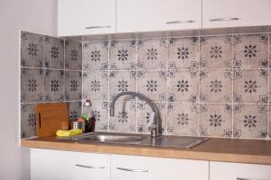 a kitchen with a sink and a tiled wall at Hara's Studio in Perdika +43 photos