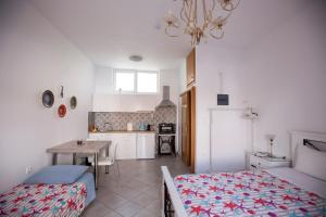 a room with two beds and a table and a kitchen at Hara's Studio in Perdika