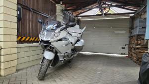 a motorcycle parked in front of a garage at ApartHotel SAVAS 1 Mini Studio and parking in Kaunas
