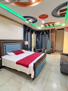 a bedroom with a large bed and chairs at Bhurban Family Apartments in Murree