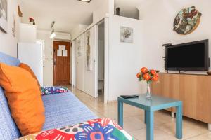 a living room with a couch and a tv at Sweet Home in Puerto Rico de Gran Canaria