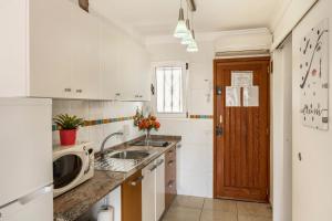 a white kitchen with a sink and a microwave at Sweet Home in Puerto Rico de Gran Canaria