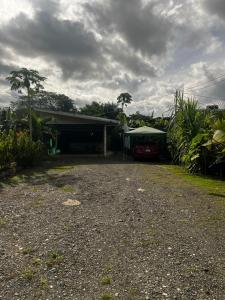 a house with a car parked in the driveway at Agujas hostel in Puerto Jiménez