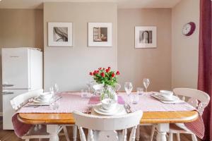 a dining room with a table and white chairs at Kates Cottages Kinnighallen in Spott +67 photos