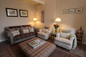 a living room with a couch and two chairs at Kates Cottages Kinnighallen in Spott