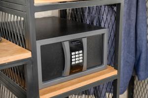 a microwave oven sitting on top of a shelf at City Port Hotel by Sea N Rent in Haifa