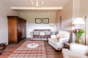 a living room with a couch and a chair at Kates Cottages Kinnighallen in Spott