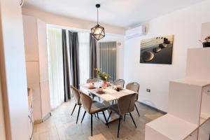 eine Küche und ein Esszimmer mit Tisch und Stühlen in der Unterkunft Bavaro 28 by Alezzi Resort in Mamaia Nord – Năvodari