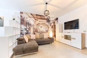 ein Wohnzimmer mit einer Couch und einem Wandbild in der Unterkunft Bavaro 28 by Alezzi Resort in Mamaia Nord – Năvodari