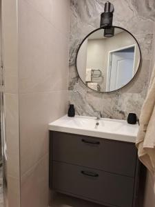 a bathroom with a sink and a mirror at Levanda apartment in Visaginas