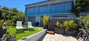 a garden with chairs and plants in front of a building at Villa HARMONY in Vallauris