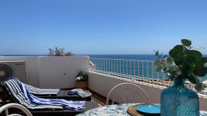 a balcony with a table and a vase with a view of the ocean at BLUE OASIS Mojácar in Mojácar