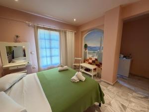 a bedroom with a green bed with two towels on it at Condillia II in Spetses