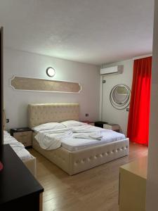 a bedroom with a white bed and a red curtain at Hotel Restaurant Real in Kolgecaj