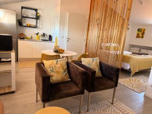 a living room with a chair and a kitchen at Ripado Loft in Ponta Delgada