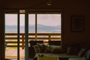 a living room with a couch and a large window at Mały Domek & Chatka Panorama in Lipowa