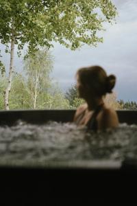 a woman sitting on a bench looking out a window at Mały Domek & Chatka Panorama in Lipowa