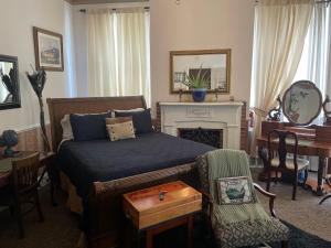 a bedroom with a bed and a desk and a chair at Olde Town Inn in Augusta