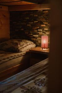 a bedroom with a bed and a red lamp on a table at Mały Domek & Chatka Panorama in Lipowa