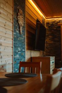 a dining room with a table and a flat screen tv at Mały Domek & Chatka Panorama in Lipowa +42 photos