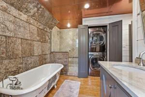 a bathroom with a tub and a washer and dryer at Sunset Nest in Highlands +55 photos