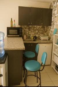 a kitchen with two blue chairs and a microwave at chalet in saint remon in Al ‘Ayn